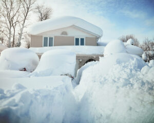 Front view of a house covered in very heavy snow