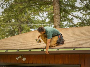 Man on House Roof Installing Gutters - K-Guard Heartland