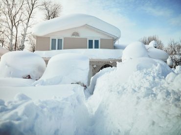 Front view of a house covered in very heavy snow