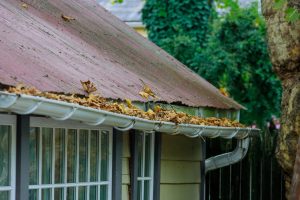 Dirty,Roof,With,Iron,Gutter,With,Autumn,Leaves,Requiring,Cleaning